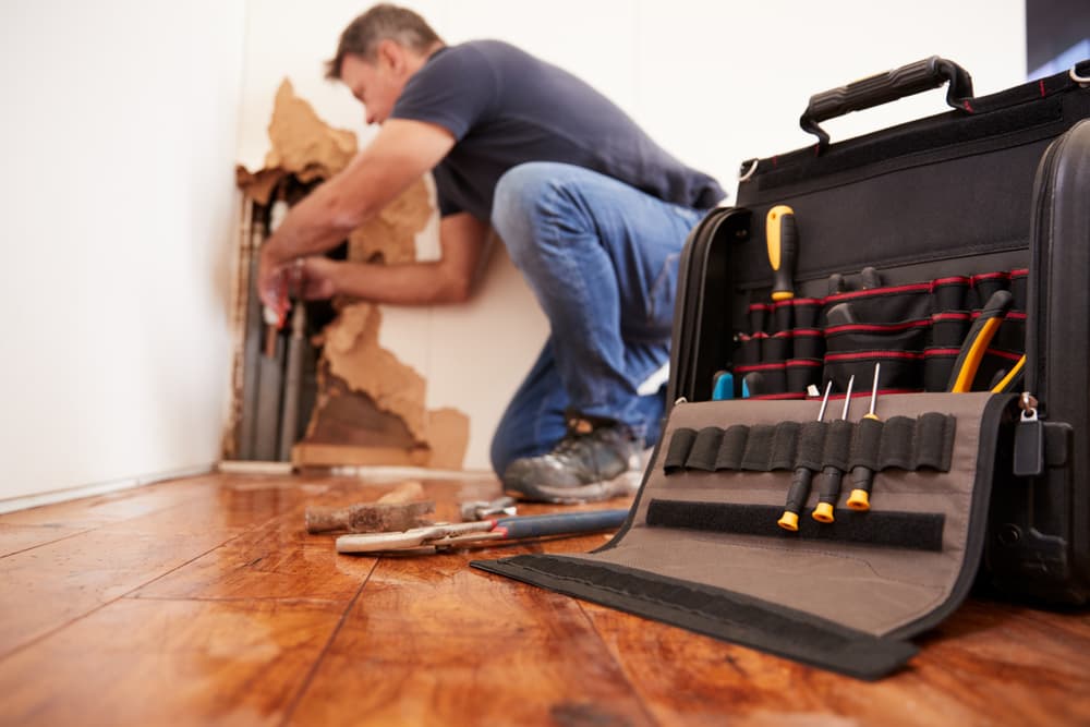 aged-man-repairing-burst-pipeplumbing